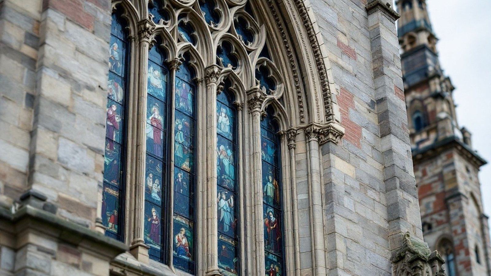 Close detail of a deep Munich-style window (blues/greens, painted figures)
